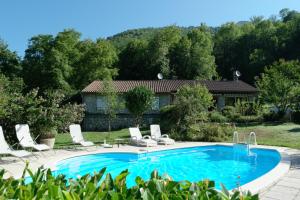 a swimming pool with chairs and a house at Maison Cancela in Siguer