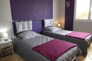 two beds in a room with purple walls at Entre seine et canal in Méry-sur-Seine