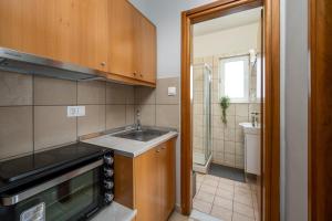 a small kitchen with a sink and a shower at Elli Beach Downtown Apartments in Rhodes Town