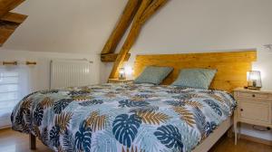 a bedroom with a bed with a blue and white comforter at Le gite du cerf 