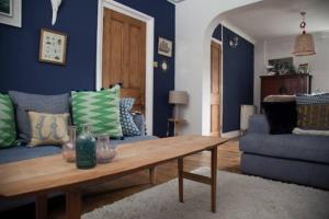 een woonkamer met een bank en een houten tafel bij Whitstable Cottage - Perfect Location in Whitstable