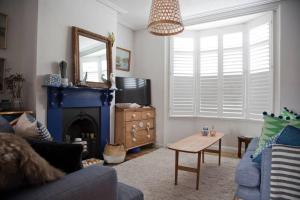 a living room with a couch and a table and a mirror at Whitstable Cottage - Perfect Location in Whitstable