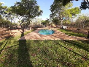 a swimming pool in the middle of a yard at Vlakkieskraal FarmStay - Bosvark Cabin in Bela-Bela
