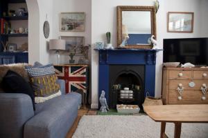 a living room with a blue couch and a fireplace at Whitstable Cottage - Perfect Location in Whitstable +16 photos