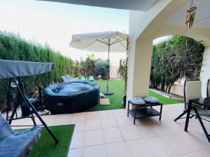 a patio with a hot tub and an umbrella at Apto. residencial en Murcia in Murcia