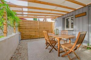 a wooden table and chairs on a patio at Le refuge in Saint-Julien-les-Villas