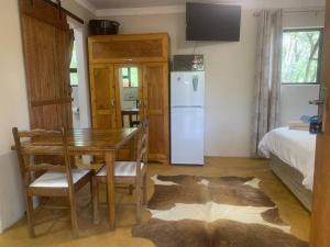 a dining room with a table and a refrigerator at Vlakkieskraal FarmStay - Bosvark Cabin in Bela-Bela