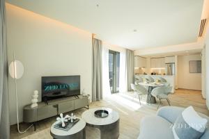 a living room with a couch and a tv at Zed Living - Ahad Residences - Tranquil 1 BR in Business Bay in Dubai