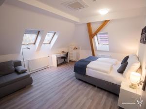 1 dormitorio con cama y sofá en Penzion Korida, en Ústí nad Labem