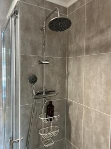 a shower with three baskets in a shower stall at Proximité de Lisbonne et des plages in Carcavelos