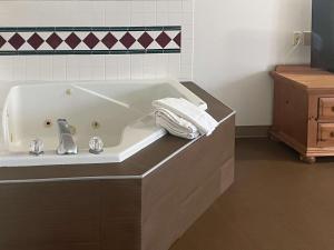 a bathroom with a bath tub with a sink at Motel 6 Portland, IN in Portland