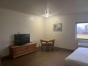 a bedroom with a television and a table with a chair at Motel 6 Portland, IN in Portland