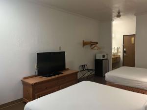 a room with two beds and a flat screen tv at Motel 6 Portland, IN in Portland