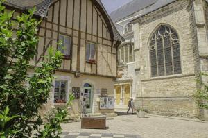 a man walking in front of a large building at Le gite des remparts in Chaource