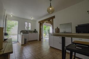 cocina con armarios blancos y suelo de baldosa en Chez pat & fred, en Balnot-la-Grange