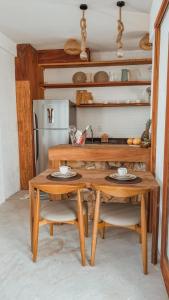 cocina con mesa de madera y 2 sillas en Saona Bangalôs, en São Gonçalo do Amarante