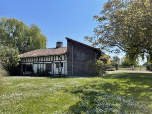 ein altes Haus auf einem Feld mit einem Rasenplatz in der Unterkunft Les epervieres in Lentilles