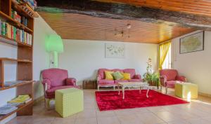ein Wohnzimmer mit rosa Stühlen und einem roten Teppich in der Unterkunft Les epervieres in Lentilles