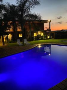 una piscina blu davanti a una casa di C and C GUEST HOUSE/ BED AND BREAKFAST a Pretoria