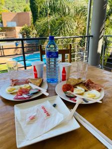 un tavolo con due piatti di cibo e una bottiglia d'acqua di C and C GUEST HOUSE/ BED AND BREAKFAST a Pretoria