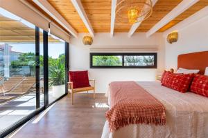 a bedroom with a large bed with red pillows at Villa Luxury Sunrise Private Pool Corralejo By Holidays Home in Corralejo