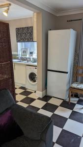 a kitchen with a white refrigerator and a checkered floor at Southsea in Coedpoeth