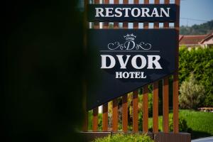 una señal para un hotel Dyson frente a una valla en Hotel Dvor, en Bijelo Polje
