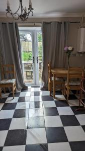 a room with a checkered floor with a table and chairs at Southsea in Coedpoeth