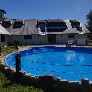 a swimming pool in front of a house at Valdemoro Hosteria in Gualeguaychú