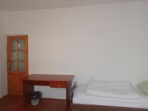 een kleine slaapkamer met een bed en een bureau bij Canal Hostel in Sheki