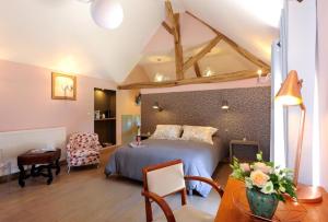 Maisons-lès-ChaourceにあるLa villa des chouettesのベッドルーム1室(ベッド1台、椅子、テーブル付)