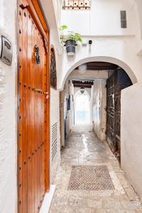an alley way in an old town with a door at Studio at the heart of Medina in Tangier
