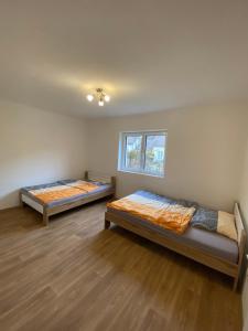 two beds in a room with wooden floors at Wienerwald Juwel in Irenental