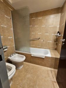 a bathroom with a tub and a toilet and a sink at Departamento Caseros Desing in Salta