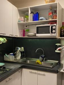 a kitchen with a sink and a microwave at Casa Elias Hostel-Av Elias in Valparaíso