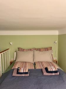 una camera con un letto con due cuscini sopra di BaseBudapest a Budapest