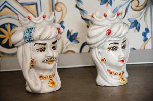 two white vases sitting on top of a table at Appartamenti La Baia del Raìs in Falcone