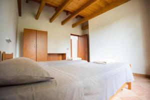 - une chambre avec un grand lit blanc dans l'établissement OASI FRANCESCANA SANT'IGNAZIO DA LACONI, à Làconi