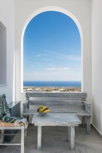 メガロホリにあるAspronisi Luxury Villa with Caldera Viewの窓際のベンチに果物を入れた鉢