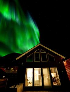 een huis met het groene noorderlicht erboven bij Rorbu Skreda in Leknes