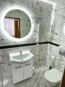 Baño blanco con lavabo y espejo en GWAREK Centrum Wypoczynkowe en Ustroń