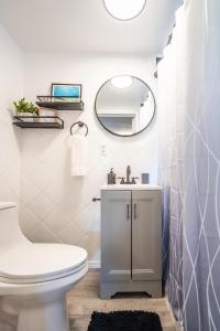 une salle de bain avec des toilettes blanches et un miroir dans l'établissement Cozy Studio w/gated parking, à Miami 12 autres photos