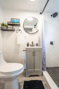 une salle de bains avec toilettes, lavabo et miroir dans l'établissement Cozy Studio w/gated parking, à Miami