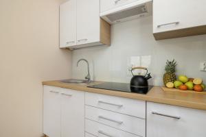扎科帕内Salwatoriańska Apartments Mountain View Zakopane by Noclegi Renters的厨房配有白色橱柜和一碗水果