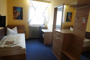 a bedroom with a bed and a desk and a window at Hotel Birnbaum in Ansbach