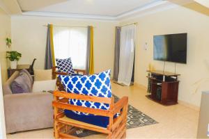 sala de estar con sofá y TV en Heavenly Homes - C en Kakamega