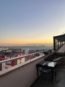 ein Balkon mit Tisch und Blick auf eine Stadt in der Unterkunft Etern Stays - C Street Apartment in Pristina