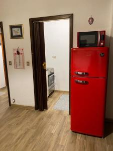 a red refrigerator with a television on top of it at Appartamento Pragelato centro con giardino privato in Pragelato