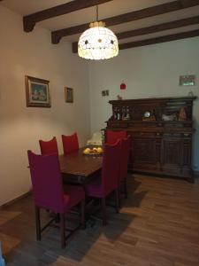 a dining room with a wooden table and red chairs at Appartamento Pragelato centro con giardino privato in Pragelato
