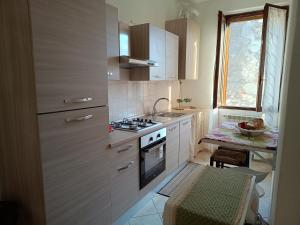 a small kitchen with a stove and a sink at I tetti di Pavia in Pavia